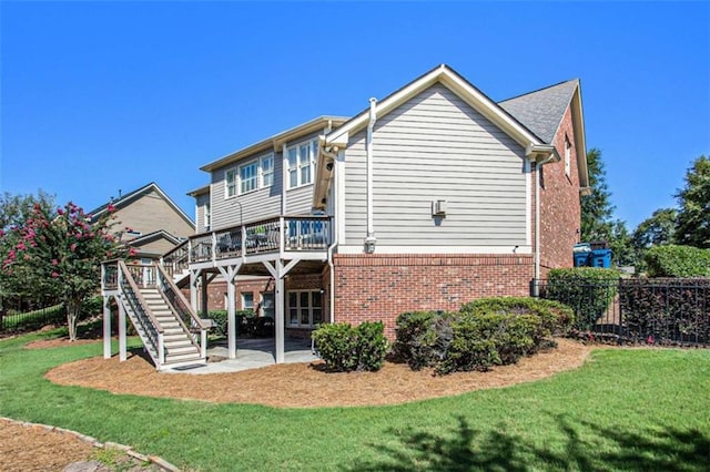 back of property with a yard, a patio, and a deck