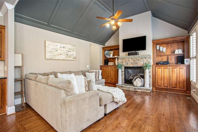 living room featuring hardwood / wood-style flooring, ceiling fan, a healthy amount of sunlight, and a stone fireplace