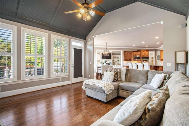 living room with ceiling fan with notable chandelier, dark hardwood / wood-style flooring, high vaulted ceiling, and crown molding