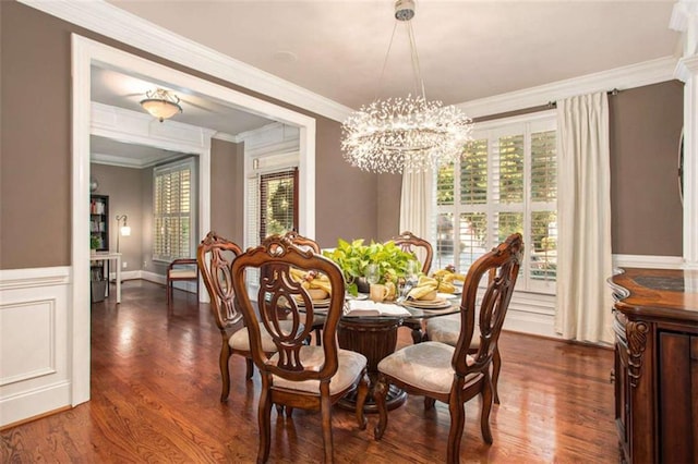 dining area featuring ornamental molding, dark hardwood / wood-style flooring, a healthy amount of sunlight, and a notable chandelier