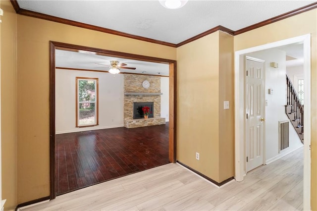 342 Spring Valley Rd, Waynesboro, GA 30830 - unfurnished living room with wood finished floors, ceiling fan, a fireplace, stairway, and crown molding