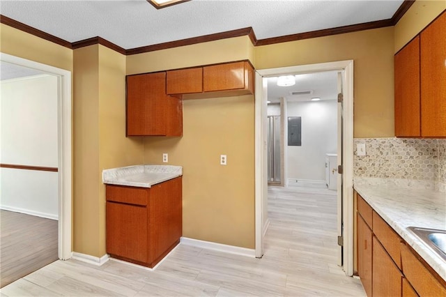 342 Spring Valley Rd, Waynesboro, GA 30830 - kitchen with brown cabinets, light wood-type flooring, light countertops, and ornamental molding