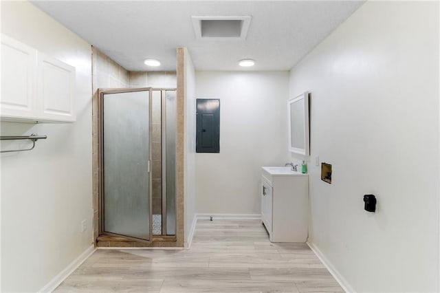 342 Spring Valley Rd, Waynesboro, GA 30830 - bathroom with electric panel, a stall shower, vanity, and wood finished floors
