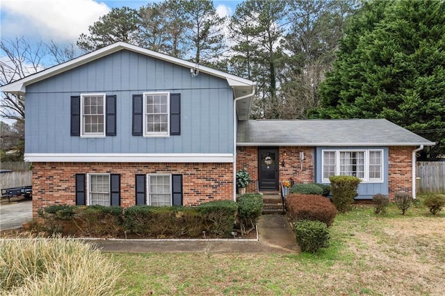 split level home featuring brick siding and a front yard