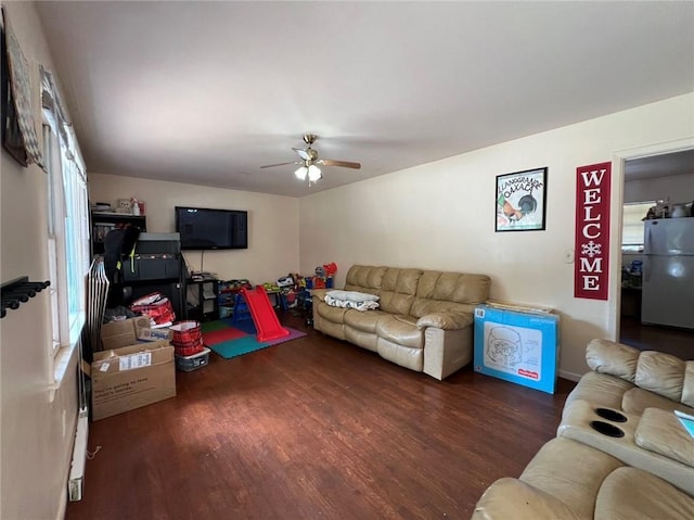 living room with ceiling fan and dark hardwood / wood-style flooring