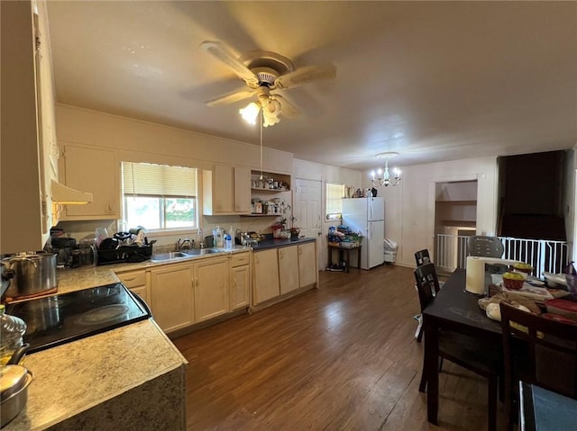 kitchen with white fridge, dark hardwood / wood-style flooring, sink, and ceiling fan with notable chandelier