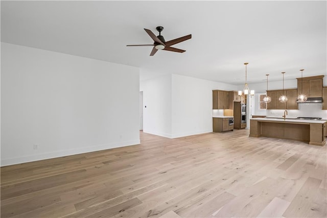 729 Keystone Dr, Woodstock, GA 30188 - unfurnished living room featuring ceiling fan, light wood-style flooring, a chandelier, and baseboards