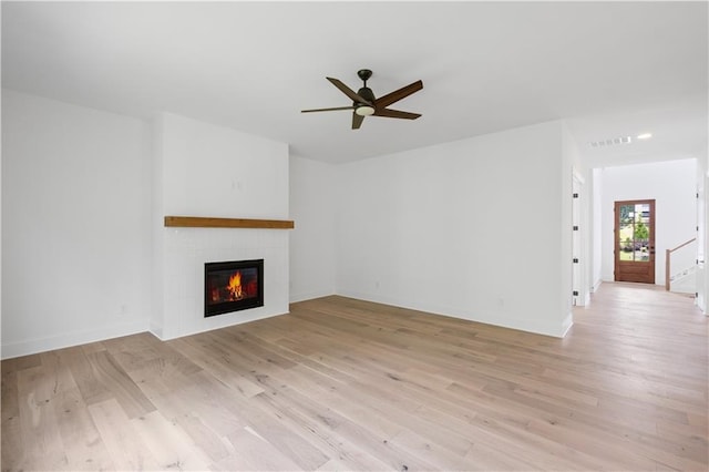 729 Keystone Dr, Woodstock, GA 30188 - unfurnished living room with ceiling fan, a tiled fireplace, light wood-style floors, and baseboards
