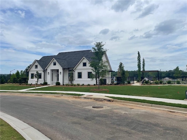 view of front of property featuring a front lawn and fence