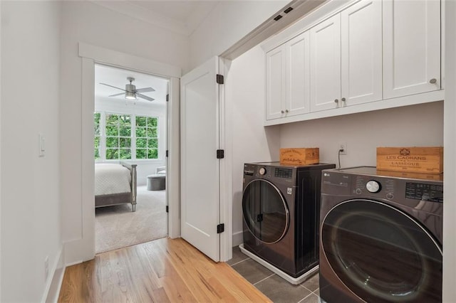 laundry area with light wood finished floors, independent washer and dryer, cabinet space, and a ceiling fan