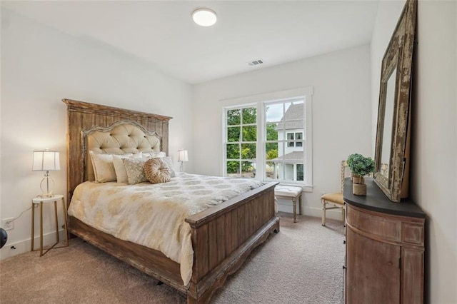 bedroom with baseboards, visible vents, and light colored carpet