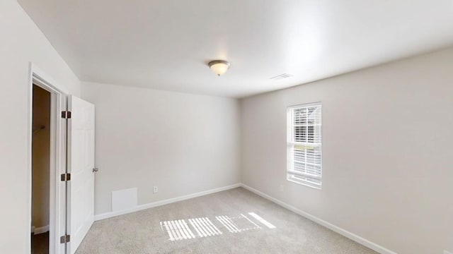 unfurnished room with light carpet and baseboards