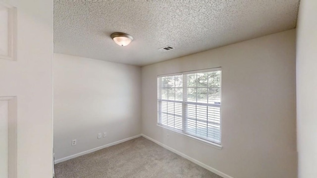 unfurnished room with a textured ceiling, light colored carpet, and baseboards