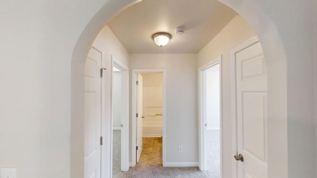 corridor with light colored carpet and baseboards