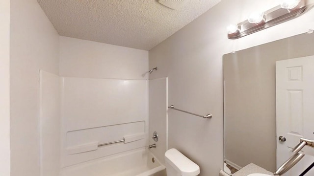 full bathroom featuring a textured ceiling, toilet, and  shower combination