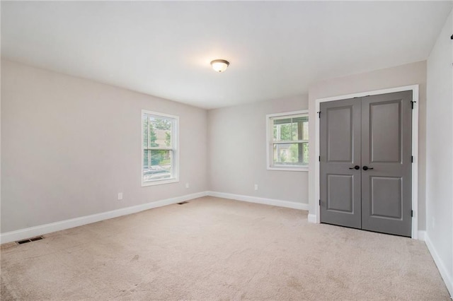 carpeted spare room featuring a wealth of natural light