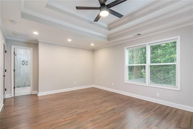 spare room featuring ornamental molding, hardwood / wood-style floors, ceiling fan, and a tray ceiling