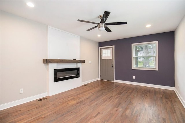 unfurnished living room with wood-type flooring and ceiling fan