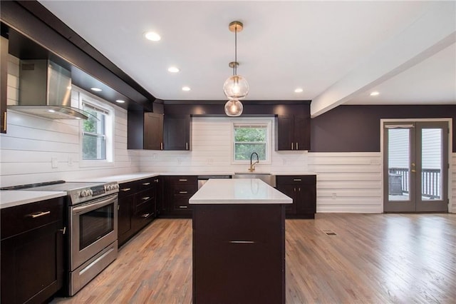 kitchen featuring a kitchen island, sink, hanging light fixtures, stainless steel appliances, and a healthy amount of sunlight