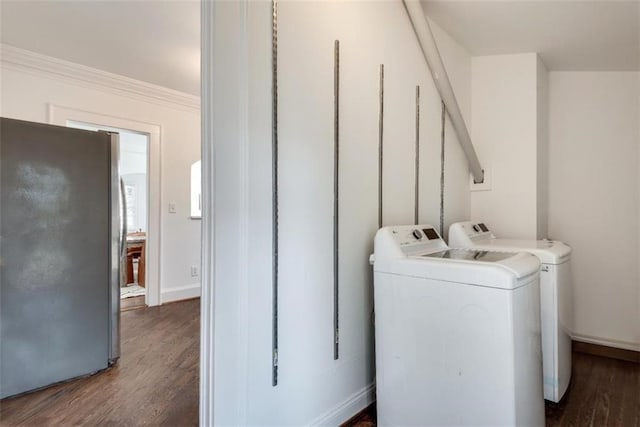 laundry area featuring dark wood-style floors, washing machine and dryer, laundry area, and baseboards