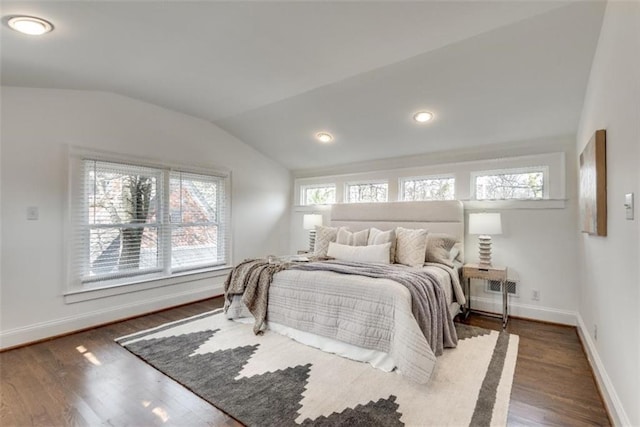 bedroom featuring lofted ceiling, wood finished floors, and baseboards