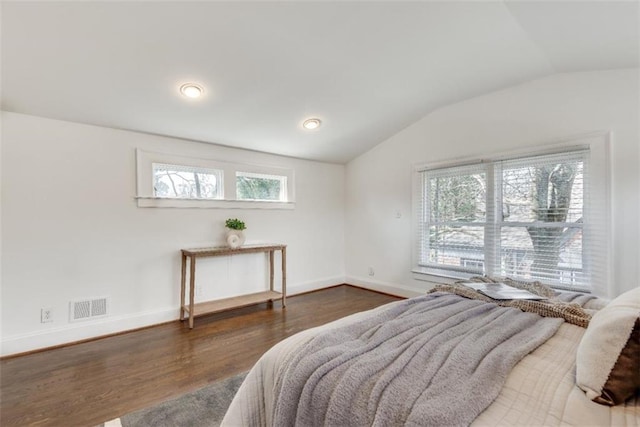 bedroom featuring lofted ceiling, wood finished floors, visible vents, and baseboards