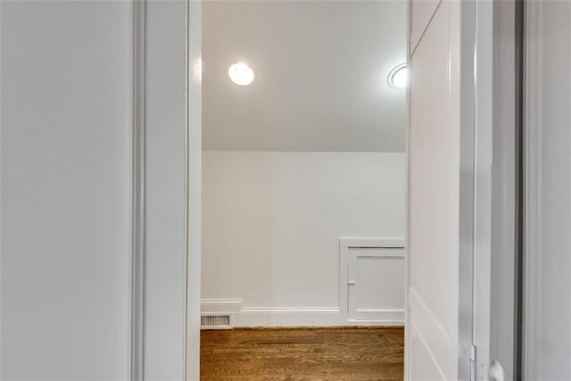 bathroom with visible vents, vaulted ceiling, baseboards, and wood finished floors