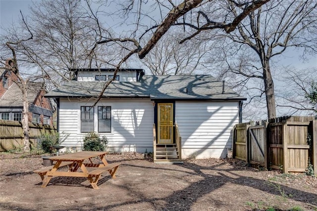 back of house featuring entry steps, fence, and a patio