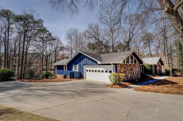 view of home's exterior featuring board and batten siding, an attached garage, and driveway