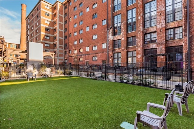 view of property's community with fence and a lawn