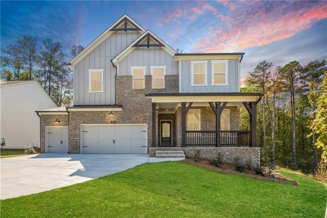 craftsman-style house with brick siding, covered porch, board and batten siding, a front yard, and driveway