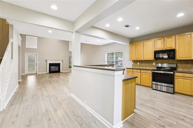 7712 Soaring Eagle Dr, Flowery Branch, GA 30542 - kitchen featuring decorative backsplash, black microwave, dark countertops, light wood-type flooring, and electric stove