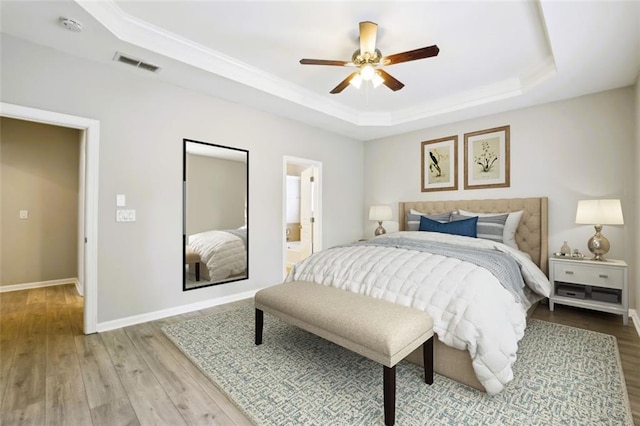 7712 Soaring Eagle Dr, Flowery Branch, GA 30542 - bedroom featuring a tray ceiling, visible vents, baseboards, and light wood-style floors