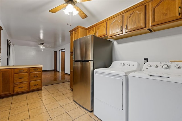 laundry area featuring ceiling fan, washer and dryer, and light tile patterned floors