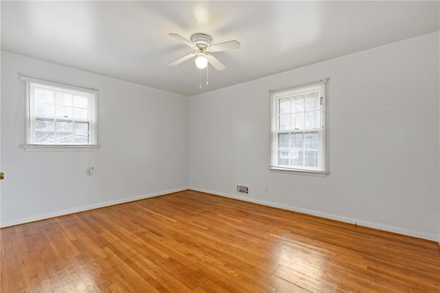 spare room with plenty of natural light, light hardwood / wood-style floors, and ceiling fan