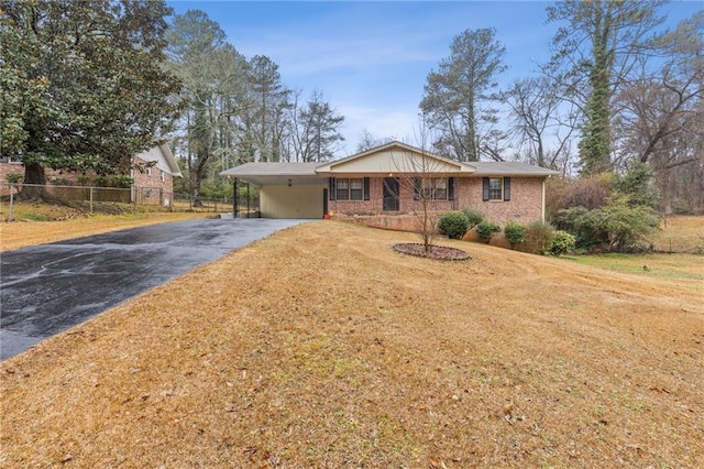 ranch-style home featuring a carport and a front yard