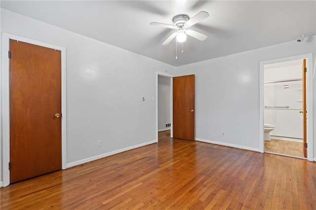 unfurnished bedroom featuring hardwood / wood-style floors and ensuite bath