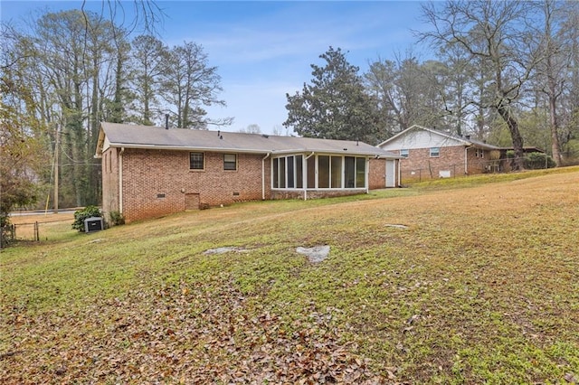 rear view of property with a sunroom and a lawn