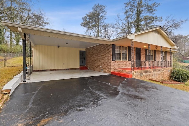 ranch-style home with a carport and covered porch