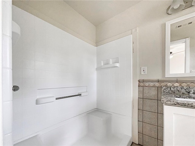 bathroom featuring vanity and tile walls