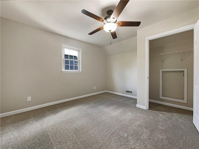 unfurnished bedroom with carpet floors, a closet, vaulted ceiling, and ceiling fan