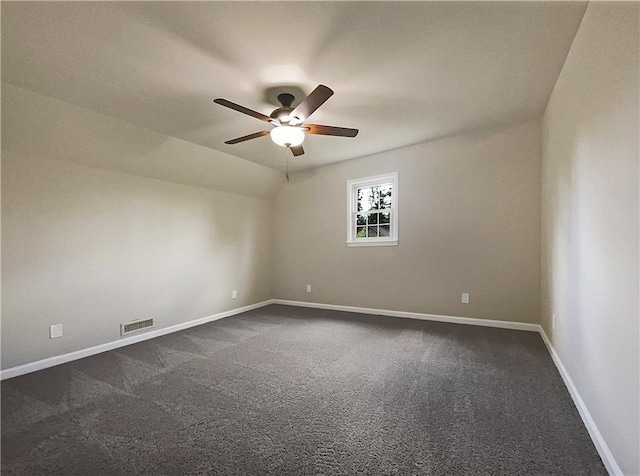 carpeted spare room featuring ceiling fan and lofted ceiling