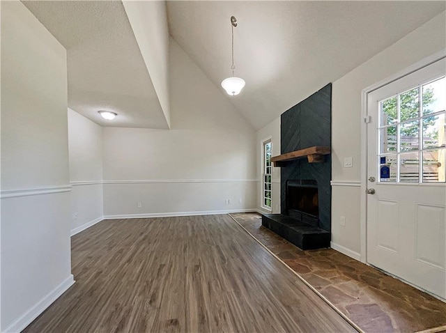 unfurnished living room featuring dark hardwood / wood-style floors, a fireplace, and vaulted ceiling