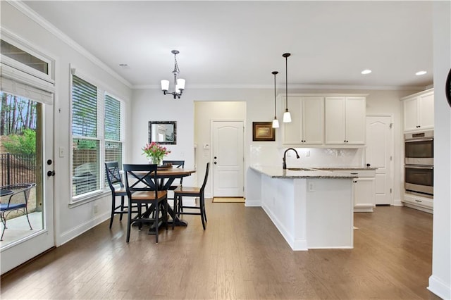 1803 Stone Bridge Way, Marietta, GA 30064 - kitchen with tasteful backsplash, double oven, ornamental molding, a peninsula, and dark wood-style flooring