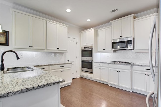 1803 Stone Bridge Way, Marietta, GA 30064 - kitchen featuring visible vents, wood finished floors, white cabinets, stainless steel appliances, and a sink