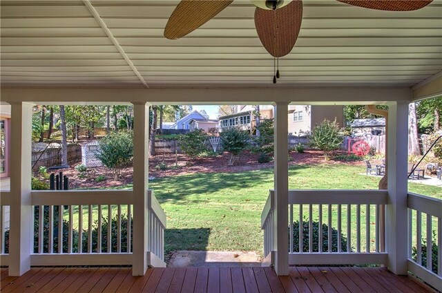 wooden deck featuring ceiling fan and a lawn