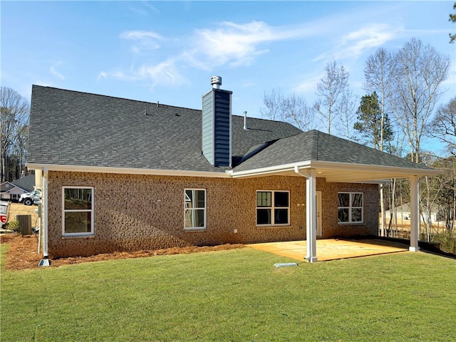 back of property with a patio area and a lawn