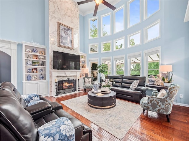 7060 Summit Rdg, Chase, Cumming, GA 30041 - living area with a high ceiling, a fireplace, a ceiling fan, hardwood / wood-style flooring, and ornamental molding