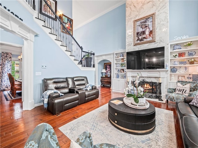 7060 Summit Rdg, Chase, Cumming, GA 30041 - living room with a high end fireplace, a high ceiling, arched walkways, wood finished floors, and stairs