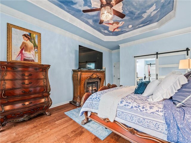 7060 Summit Rdg, Chase, Cumming, GA 30041 - bedroom featuring a tray ceiling, wood finished floors, a glass covered fireplace, baseboards, and ceiling fan